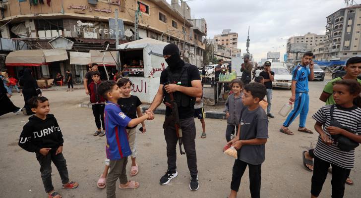 عنصر من المقاومة الفلسطينية مع أطفال غزة