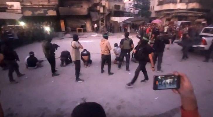 وقوف عناصر من حماس خلف رجال معصوبي الأعين ومقيدين