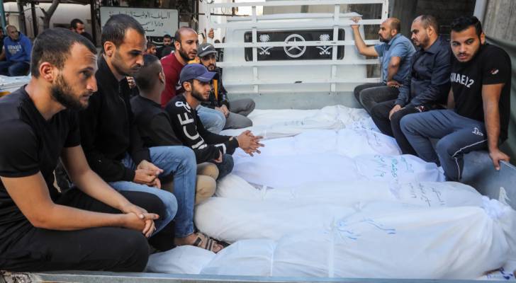 شباب فلسطينين ينقلون رفات شهداء في قطاع غزة بواسطة شاحنة