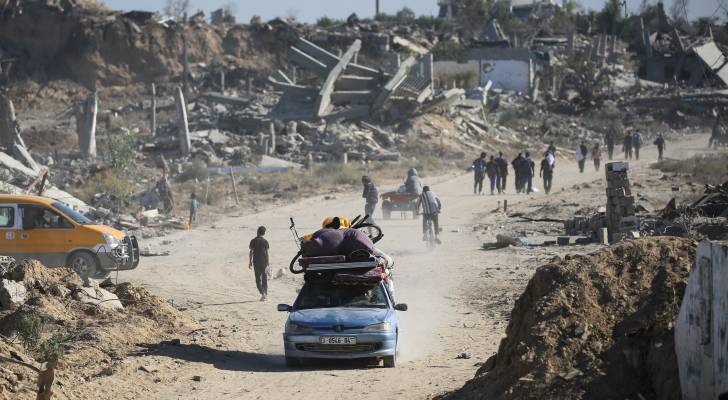 رجل يقود سيارة محملة بممتلكاته بينما يعود الفلسطينيون المهجرون إلى منازلهم في منطقة الزهراء