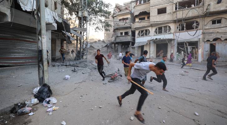 فلسطينيون يهربون من منطقة استهدفها جيش الاحتلال بغارة جوية