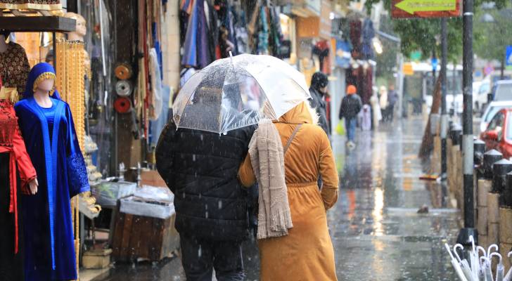رجل و سيدة يسيران تحت المطر
