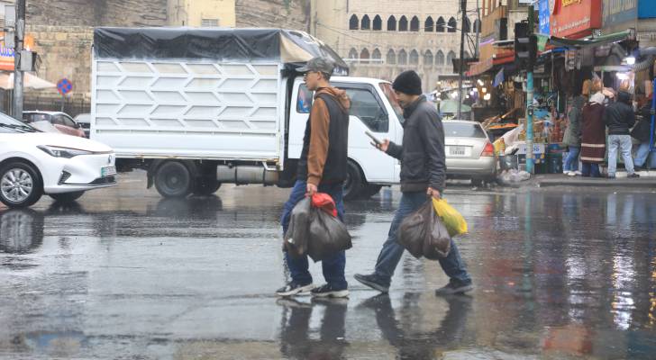 رجلان يسيران في احدى شوارع العاصمة عمان