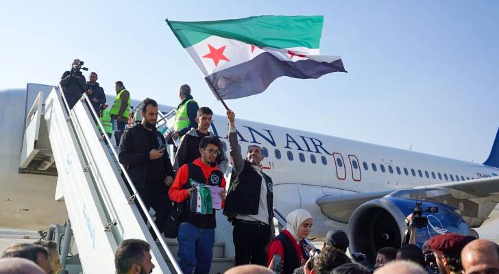 مواطنين سوريين  يحملون علم سوريا الجديد