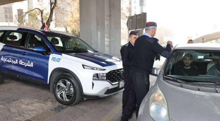 الأمن العام يباشر بلصق وتوزيع العلم الأردني
