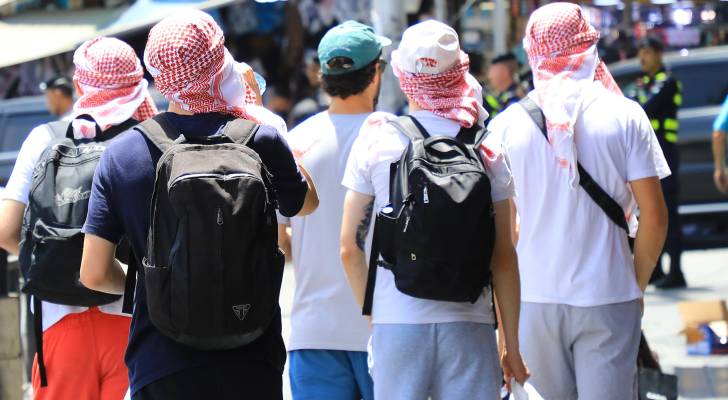 مواطنون يسيرون في اجواء مشمسة