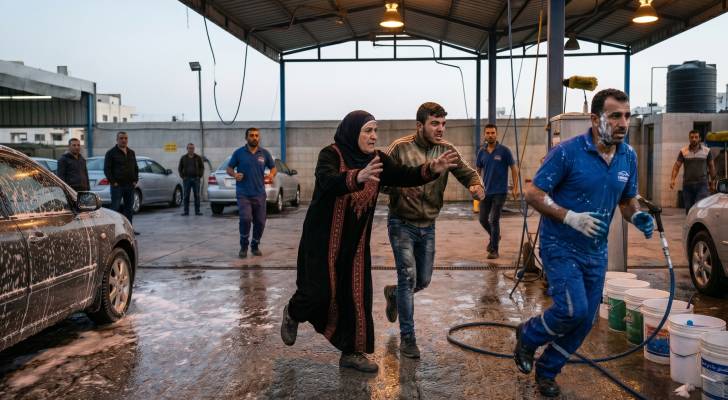 صورة معدة بالذكاء الاصطناعي تبين أمراة وابنها يعتدون بالضرب على عامل في محطة غسيل سيارات في مصر
