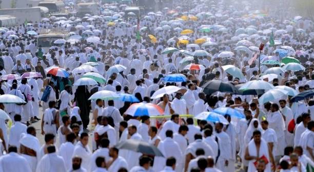حجاج يحملون مظلات من حرارة الشمس