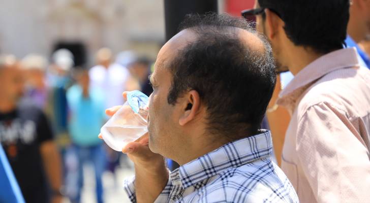 مواطن يشرب المياة في أجواء حارة