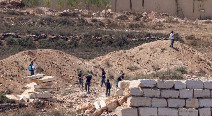 يتجمع مستوطنون إسرائيليون أمام منازل فلسطينية
