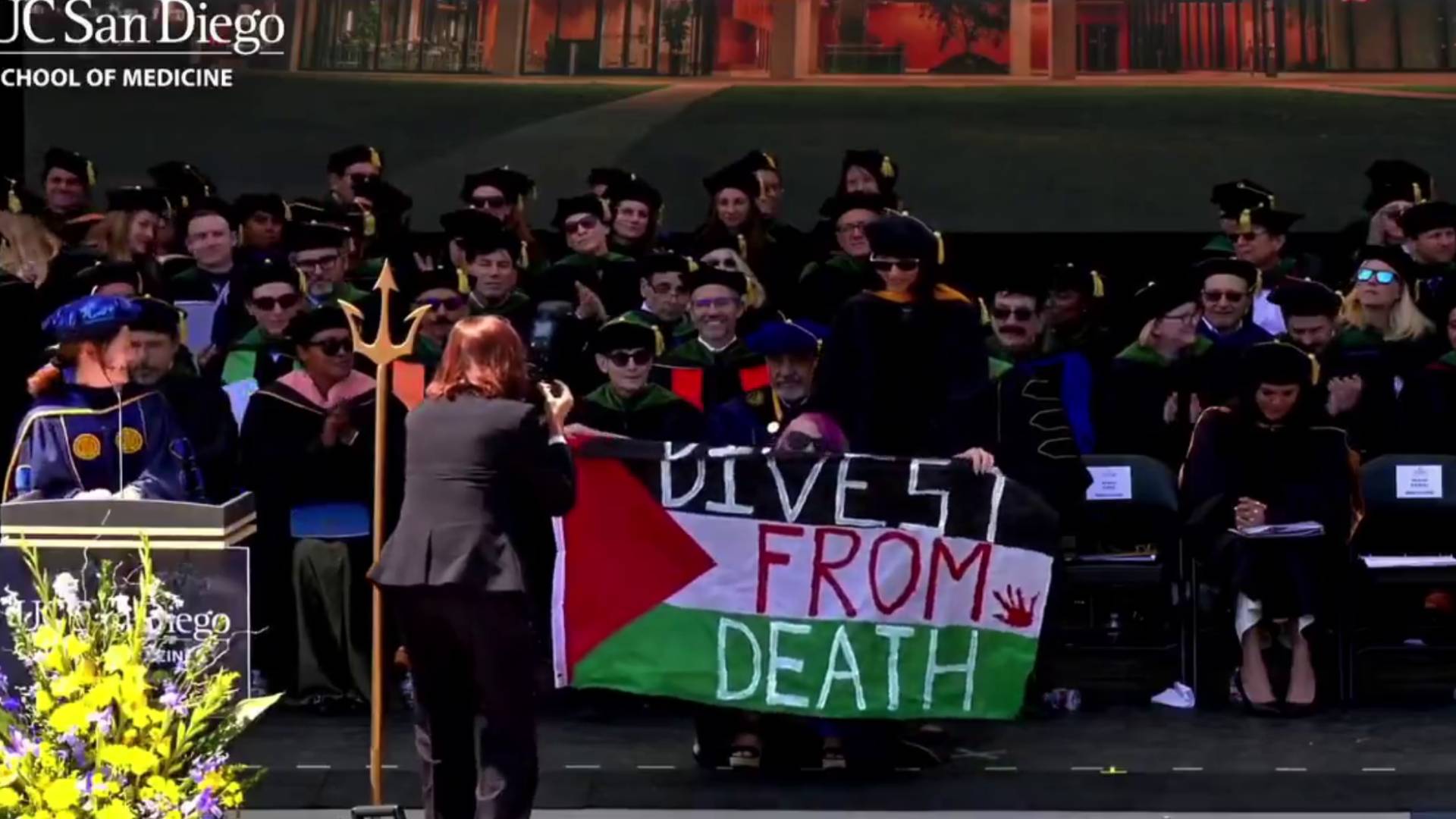 UC San Diego medical graduate unfurls “Divest From Death” banner
