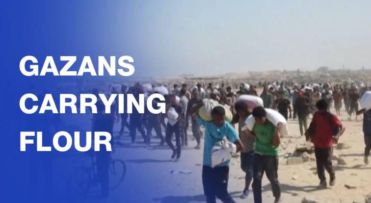 Palestinians in northern Gaza carry bags of flour through ruins