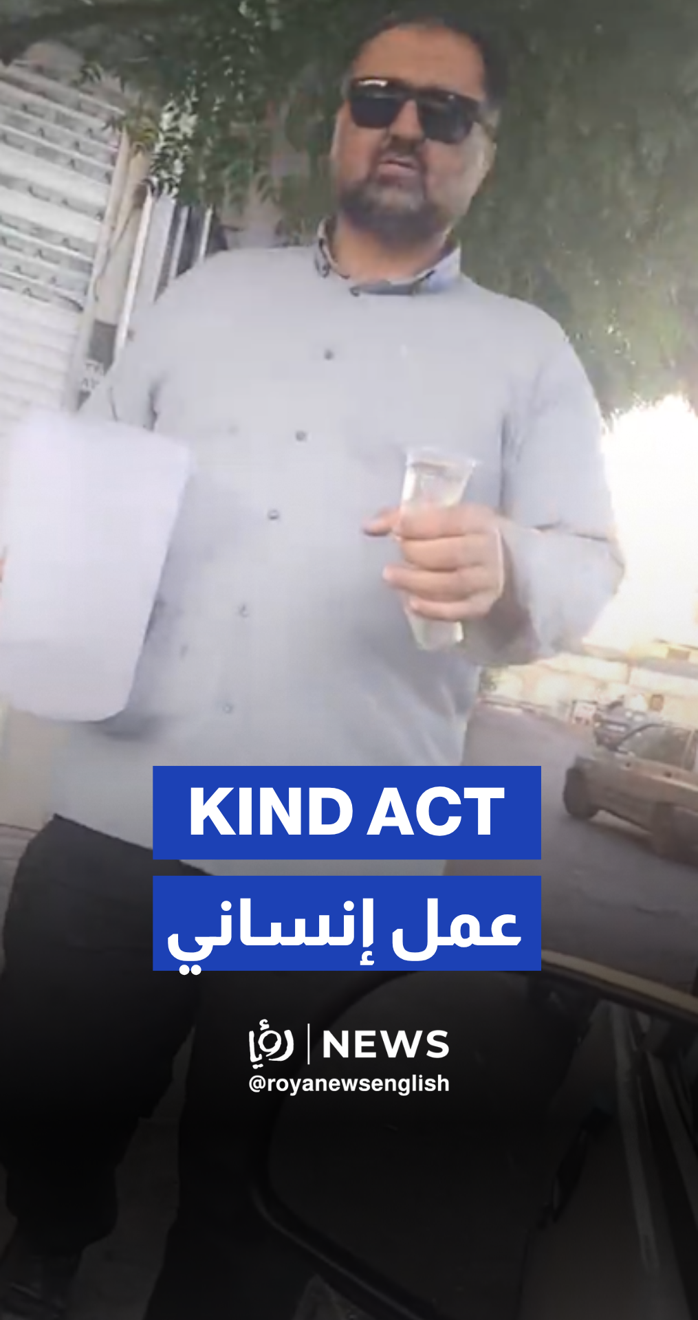 Iranian man offers cold water to people waiting in gas station line in Tehran