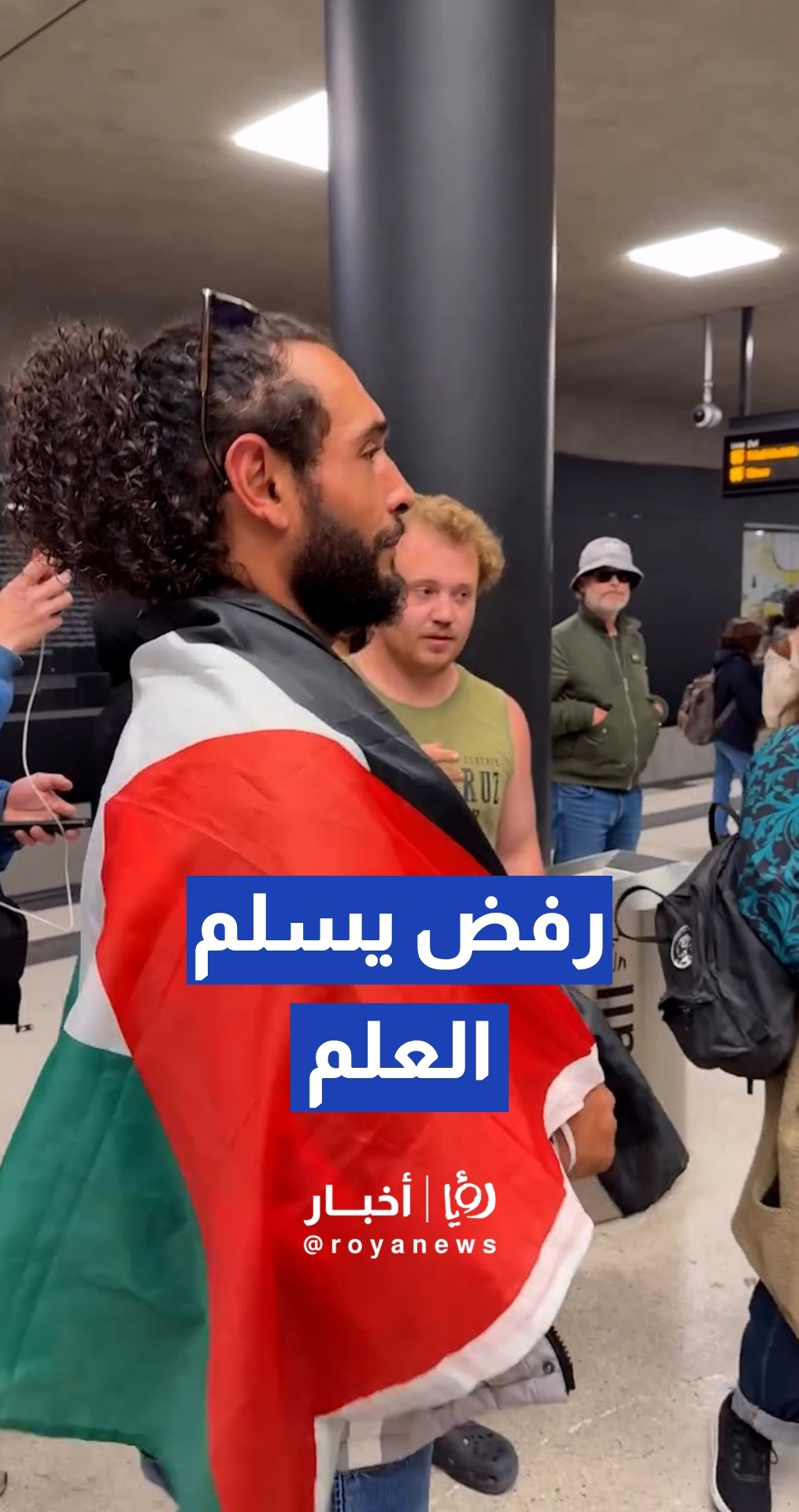 شاب مصري يرفض تسليم علم فلسطين للشرطة الألمانية ويضعه على كتفيه