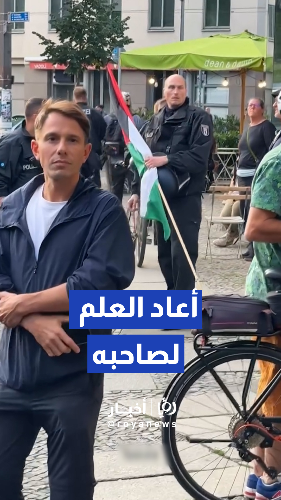 شرطي في برلين يعيد العلم الفلسطيني لمتظاهر بعد مصادرة دراجته